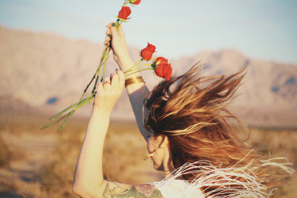 rediscover joy -woman running freely with her hair down and roses in hands